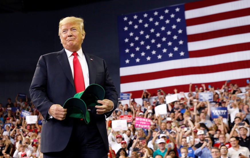 U.S. President Donald Trump holds &quot;Make Our Farmers Great Again!&quot; hats as he arrives for a &quot;Make America Great Again&quot; rally in Evansville, Indiana, U.S. August 30, 2018. REUTERS/Ke ...