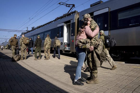 23.03.2023, Ukraine, Kramatorsk: Ein ukrainischer Soldat umarmt seine Liebste am Bahnhof in Kramatorsk, Ukraine. Foto: Evgeniy Maloletka/AP/dpa +++ dpa-Bildfunk +++