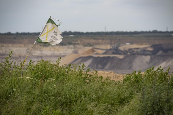 Blick in den Tagebau bei Luetzerath, ein Wimpel von Alle Doerfer Bleiben flattert im Wind, Rund um den Braunkohle-Tagebau Garzweiler, am 26.05.2022 Â