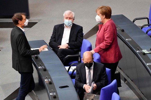 Karl Lauterbach im Bundestag, im Gespräch mit Bundeskanzlerin Angela Merkel und Bundesinnenminister Horst Seehofer. 