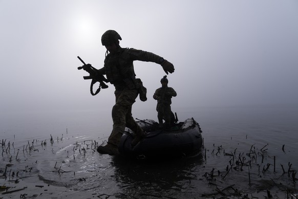 ARCHIV - 15.10.2023, Ukraine, Cherson: Ein ukrainischer Soldat springt am Ufer des Dnipro-Flusses an der Frontlinie nahe Cherson aus dem Boot. (zu dpa: «Medien: Brückenkopf am Dnipro kostet Kiew viele ...