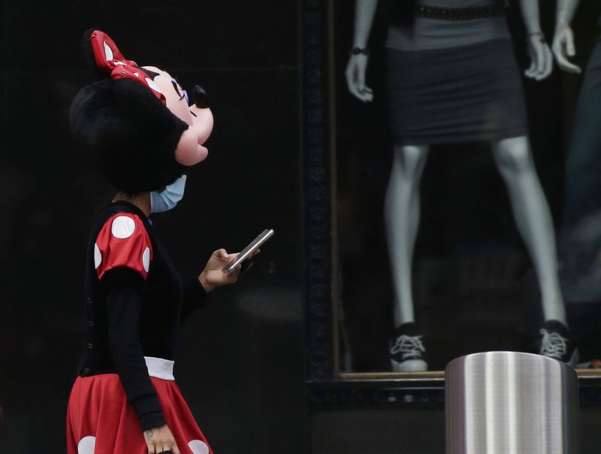 A worker dressed as Minnie Mouse wears face masks to protect from and to prevent the spread of COVID-19 in Times Square in New York City on Wednesday, October 21, 2020. Recently, a few neighborhoods i ...