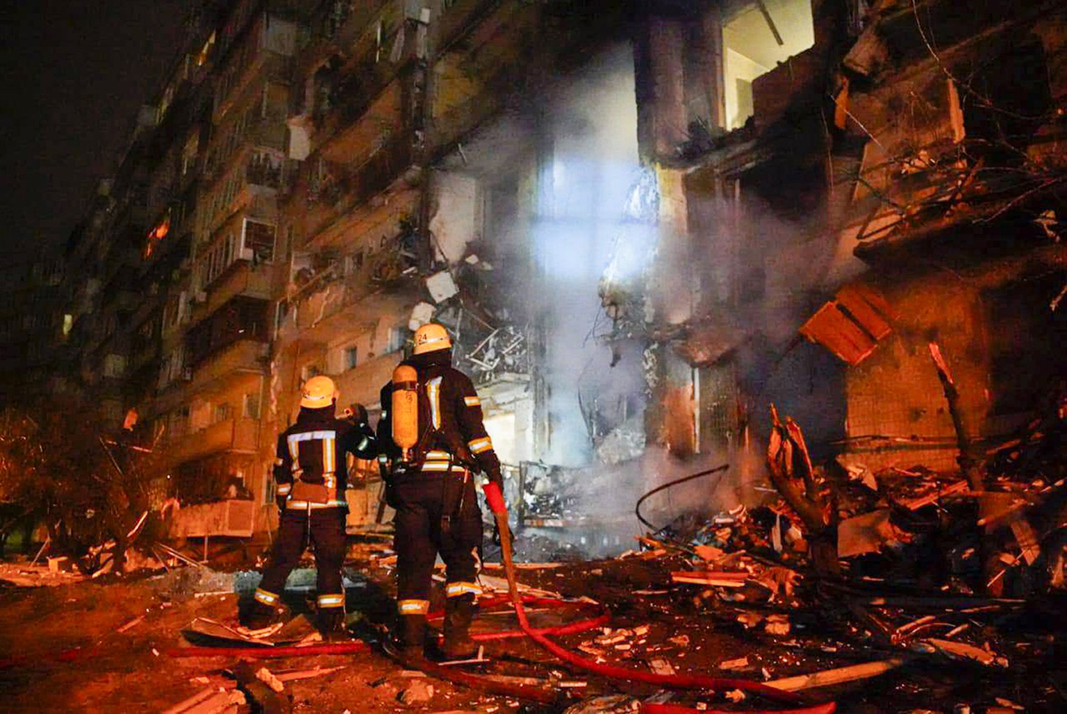 Die Feuerwehr löscht brennende Häuser nach einem Raketenangriff in Kiew, 25. Februar. 
