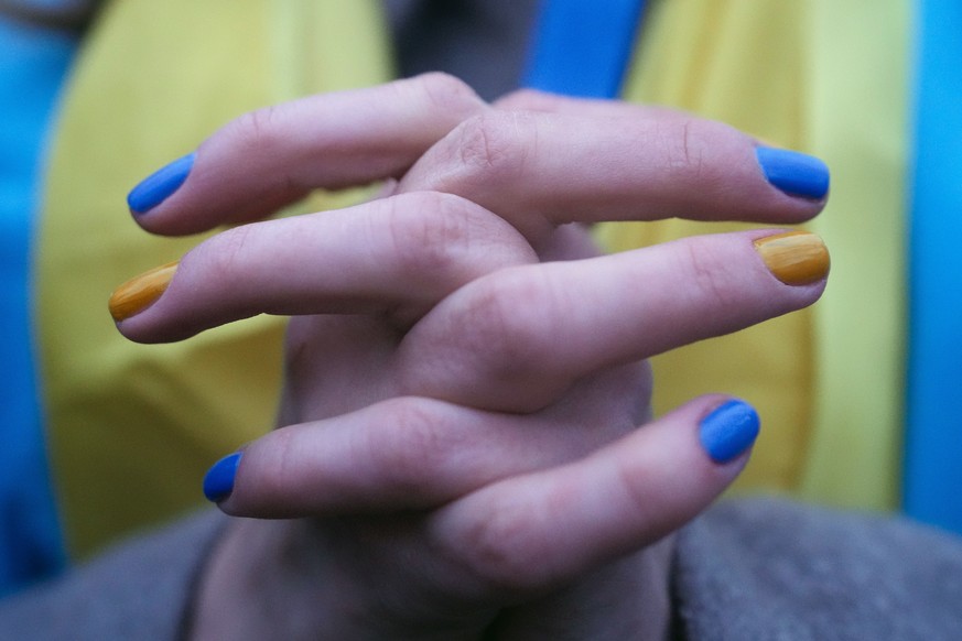 FILE - A woman, her fingernails painted in the colors of the Ukrainian national flag, takes part in a protest against the escalation of the tension between Russia and Ukraine, near the Russian embassy ...