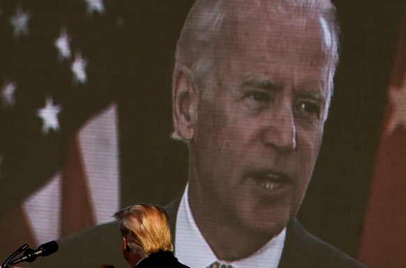 Democratic U.S. presidential nominee and former Vice President Joe Biden is seen on a screen as U.S. President Donald Trump watches a campaign add during his campaign rally at Oakland County Internati ...