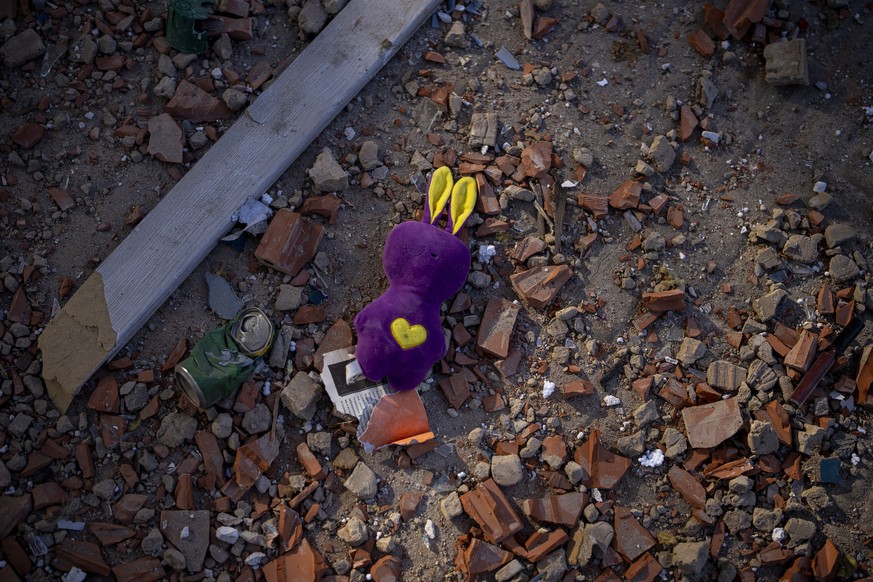 26.02.2022, Ukraine, Kiew: Ein Spielzeug liegt in den Trümmern eines Wohnhauses.