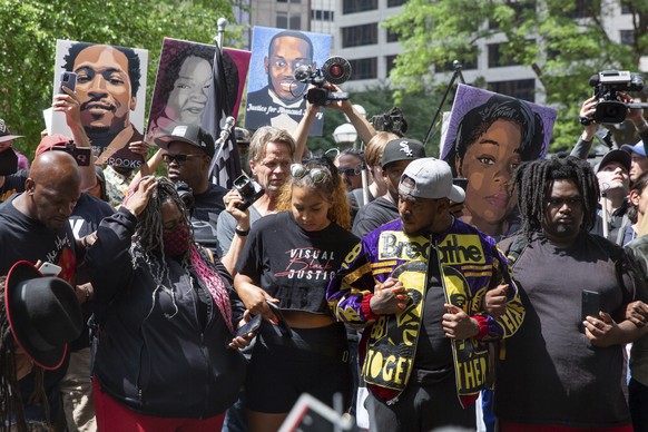 25.06.2021, USA, Minneapolis: Menschen verschr�nken die Arme miteinander, als das Urteil f�r Derek Chauvin vor dem Hennepin County Government Center in Minneapolis, Minnesota verlesen wird. Nach der V ...