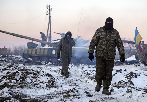 epa04544462 A picture made available 01 January 2015 shows Ukrinian soldiers walking past tanks at a position near Peski village, Donetsk area, Ukraine, 31 December 2014, few hours before the 2015 cel ...