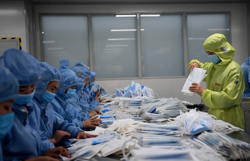 In Changyuan prüft ein Inspekteur die Qualität von Gesichtsmasken, bevor diese ins Krisengebiet geliefert werden.