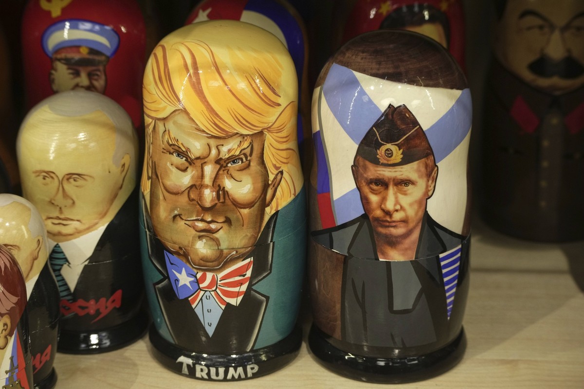 18.03.2025, Russland, St. Petersburg: Traditionelle russische Holzpuppen, Matrjoschkas genannt, die den russischen Präsidenten Wladimir Putin (r) und den US-Präsidenten Donald Trump (M) darstellen, we ...