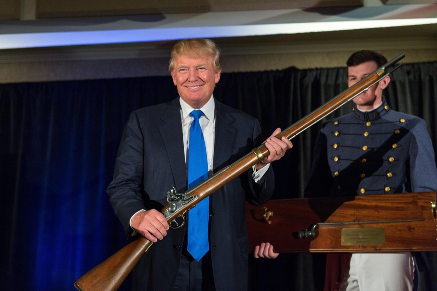 CHARLESTON, SC - FEBRUARY 22: Reality TV host and New York real estate mogul Donald Trump holds up a replica flintlock rifle awarded him by cadets during the Republican Society Patriot Dinner at the C ...