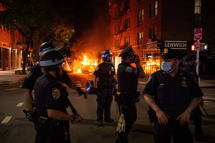 200530 Police in front of a police car that has been set one fire during a protest over the death of George Floyd, on May 30, 2020 close to Union Square in the Manhattan borough of New York, NY, USA.  ...