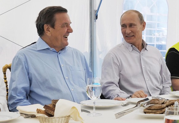 epa02901816 Russian Prime Minister Vladimir Putin (R) and Former German Chancellor and Chairman of the Nord Stream shareholders' committee Gerhard Schroeder (L) laugh during their meeting with staff m ...