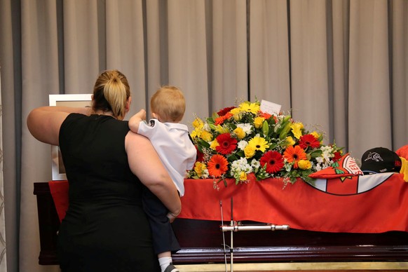 Mourners stand near the coffin of late RFS volunteer Geoffrey Keaton during his funeral in Buxton, New South Wales, Australia January 2, 2020, in this picture obtained from social media. Mandatory cre ...