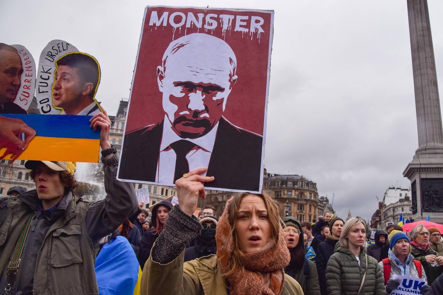März 2022: Eine Aktivistin zeigt bei einem Protest in London ein Bid des russischen Präsident Putin. Überschrieben ist es mit "Monster".