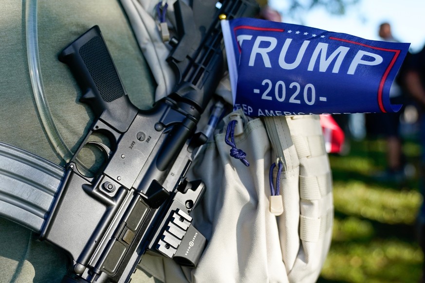 A supporter of U.S. President Donald Trump stands with far-right activists and self-described militia members during a a rally on the day of the Kentucky Derby horse race in Louisville, Kentucky, U.S. ...