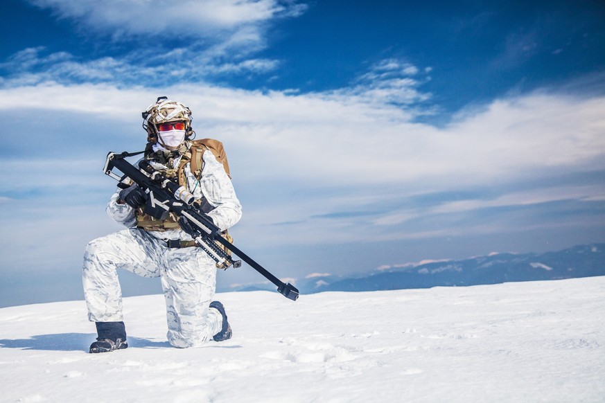 Army soldier with Sniper rifle in action in the Arctic. He wears chest rig, backpack, suffers from extreme cold, strong wind, but endures while mission continues, in snow desert