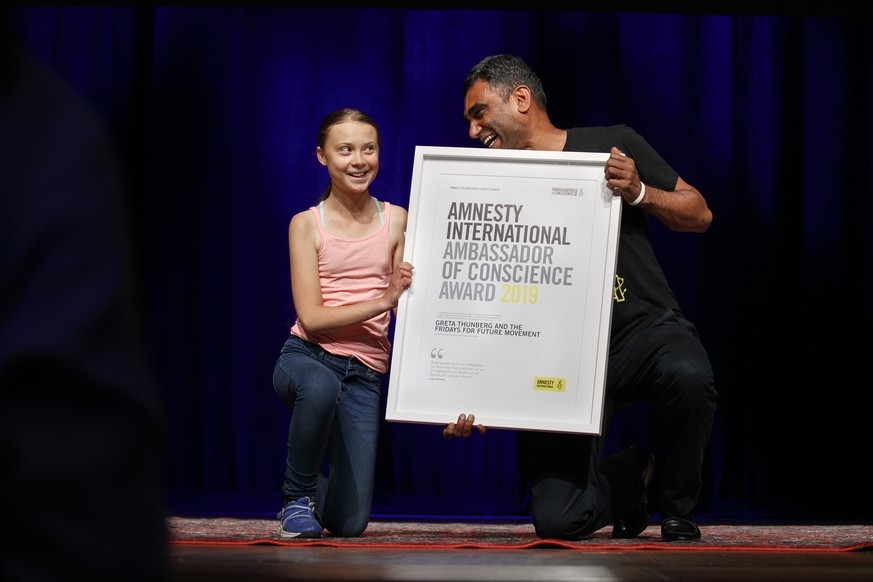 Swedish climate activist Greta Thunberg, 16, left, accepts the Ambassador of Conscience Award from Amnesty International Secretary General Kumi Naidoo, at George Washington University, Monday, Sept. 1 ...