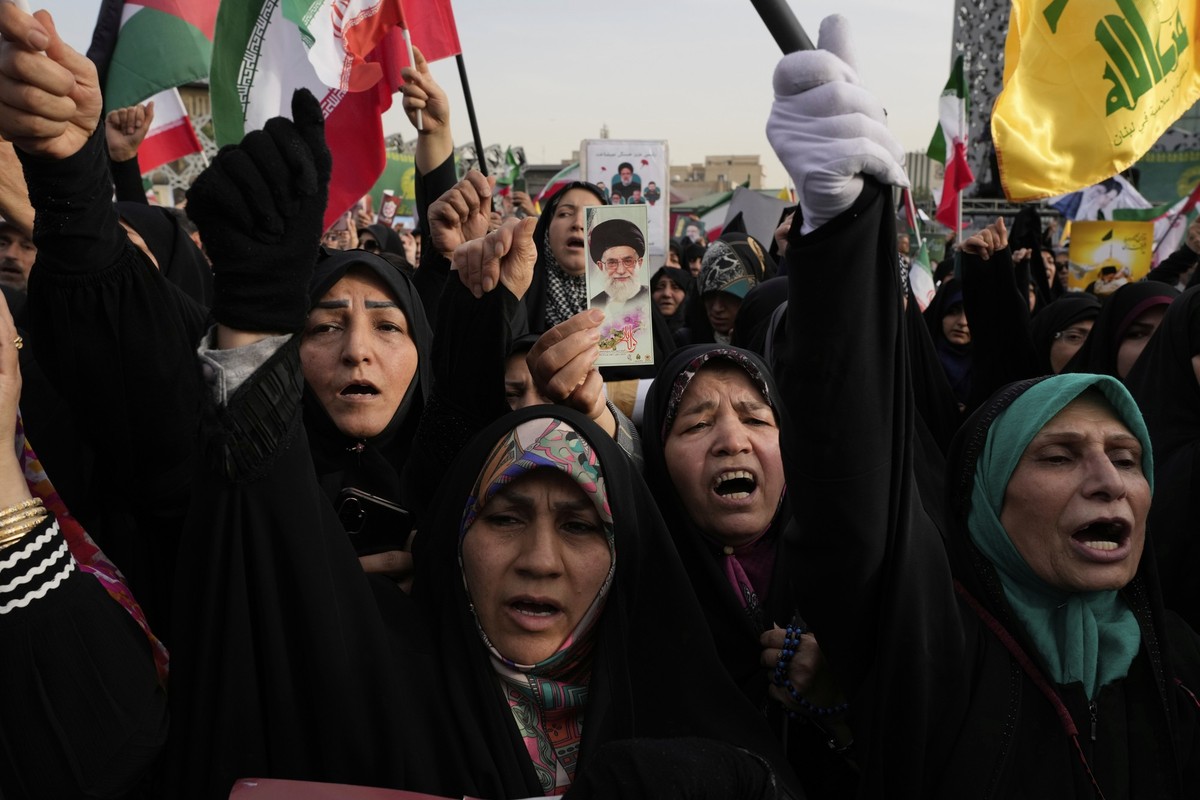 15.05.2025, Iran, Teheran: Frauen skandieren Slogans, während eine von ihnen ein Plakat des iranischen Obersten Führers Ayatollah Ali Chamenei hochhält. Die Zeremonie findet anlässlich des ersten Tode ...