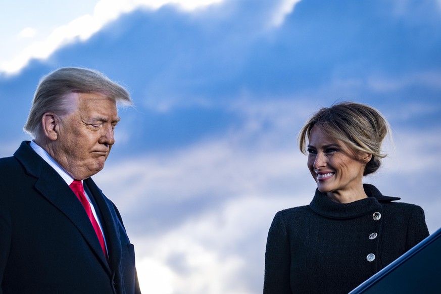 JOINT BASE ANDREWS, MARYLAND - JANUARY 20: President Donald Trump and First Lady Melania Trump pause while speaking to supporters at Joint Base Andrews before boarding Air Force One for his last time  ...