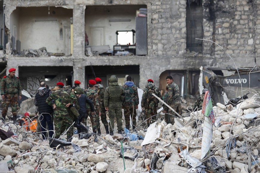 07.02.2023, Syrien, Aleppo: Russische Soldaten und syrische Sicherheitskräfte inspizieren die Trümmer eingestürzter Gebäude. Die Zahl der Toten im Erdbebengebiet an der türkisch-syrischen Grenze steig ...