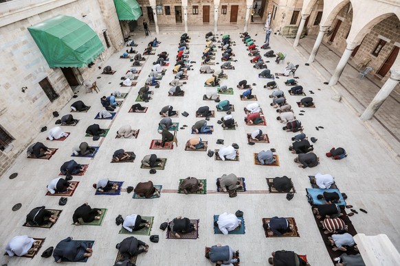 24.05.2020, Palästinensische Autonomiegebiete, Gaza City: Muslime, die Gesichtsmasken tragen, bieten das Eid al-Fitr-Gebet an, während sie in einer Moschee, die das Ende des heiligen Monats Ramadan ma ...