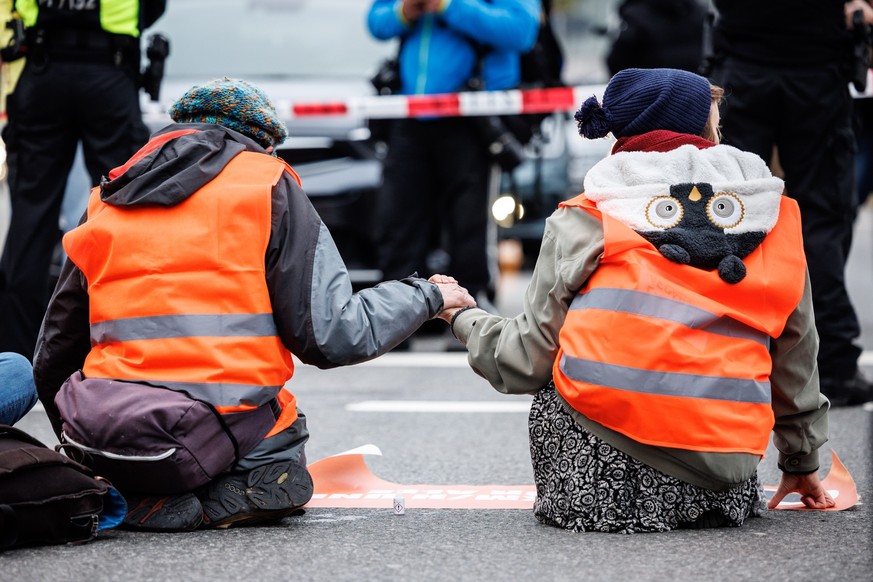 dpatopbilder - 05.12.2022, Bayern, München: Aktivisten der Klimaschutz-Initiative &quot;Letzte Generation&quot; haben sich am Stachus mit ihren Händen auf die Straße geklebt. Foto: Matthias Balk/dpa + ...