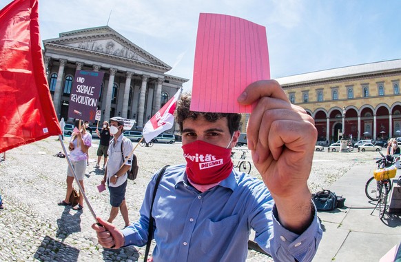 June 16, 2021, Munich, Bavaria, Germany: Ates Guerpinar of die Linke demonstrates with healthcare workers and shows a red card during the Gesundheitskonferenz.Taking a pause from the Gesundheitskonfer ...