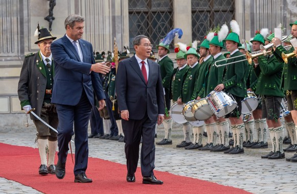 ARCHIV - 20.06.2023, Bayern, München: Chinas Premierminister Li Qiang (l) wird in der Residenz München von Markus Söder, (CSU) Ministerpräsident von Bayern, mit der Ehrenformation der Gebirgsschützen  ...