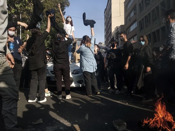 Iranians woman protest a 22-year-old woman Mahsa Amini's death after she was detained by the morality police, in Tehran, Saturday, Oct. 1, 2022. In this photo taken by an individual not employed by th ...