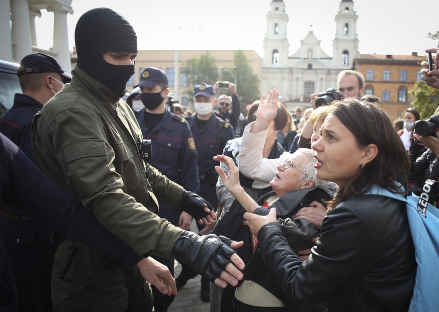 Women gesture, standing in front of a police line during an opposition rally to protest the official presidential election results in Minsk, Belarus, Saturday, Sept. 12, 2020. (Tut.by via AP)