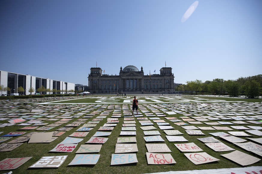 BERLIN, GERMANY - APRIL 24: Activist with the Fridays for Future movement pin to lay thousands of protest signs and banners used in the protests up to this days, in front of the Bundestag during a pro ...