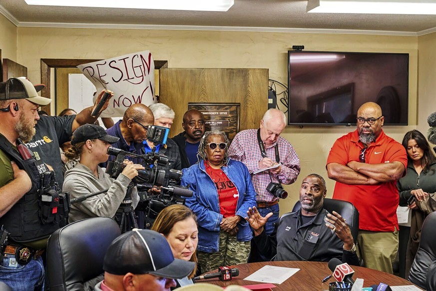 In this photo provided by the Southwest Ledger, Idabel Mayor Crain Young, seated right, at table with hands up, speaks at the McCurtain County Commissioners meeting in Idabel, Okla., Monday, April 17, ...