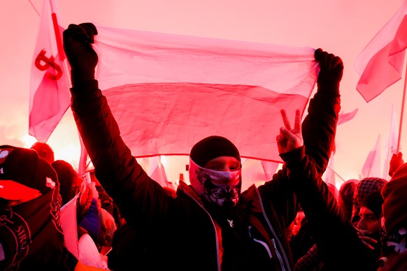 11.11.2020, Polen, Warschau: Menschen nehmen mit Fahnen am Unabhängigkeitsmarsch teil. Trotz eines Verbots sind Tausende polnische Nationalisten und Rechtsradikale durch die Stadt gezogen. Foto: Grzeg ...