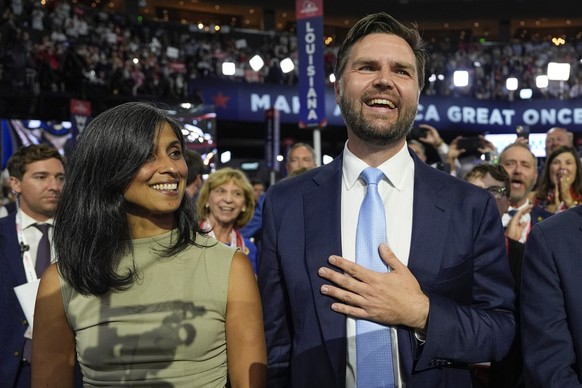 Republican vice presidential candidate Sen. JD Vance, R-Ohio, and his wife Usha Chilukuri Vance arrive on the floor during the first day of the 2024 Republican National Convention at the Fiserv Forum, ...