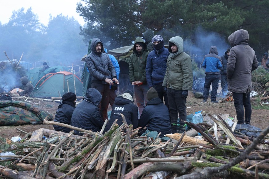 GRODNO REGION, BELARUS - NOVEMBER 14, 2021: Migrants in a tent camp on the Belarusian-Polish border. The migrant crisis on the border of Belarus with Poland, Lithuania, and Latvia escalated on Novembe ...