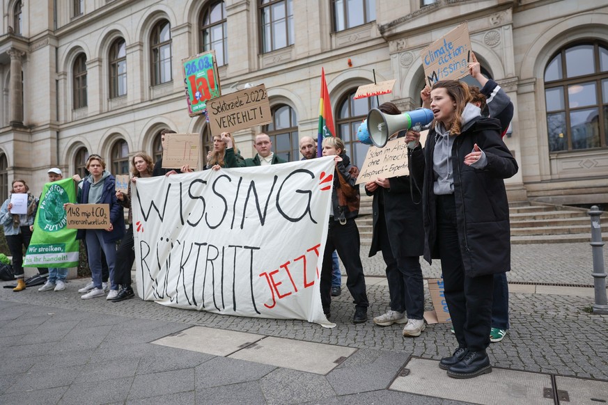 21.03.2023, Berlin: Aktivisten von &quot;Fridays for future&quot; mit Luisa Neubauer (r) fordern vor dem Bundesverkehrsministerium den Rücktritt von Bundesverkehrsminister Wissing (FDP). Foto: Jörg Ca ...