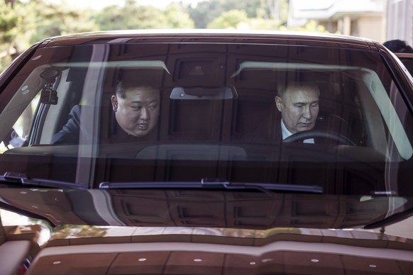 19.06.2024, Nordkorea, Pjöngjang: Auf diesem von der staatlichen russischen Nachrichtenagentur Sputnik via AP veröffentlichten Foto fahren der russische Präsident Wladimir Putin (r) und Nordkoreas Mac ...