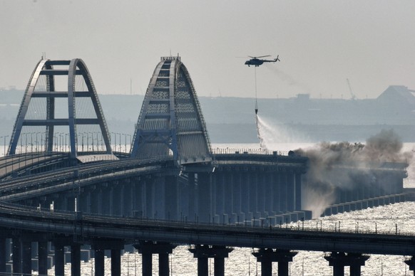 Russia Crimean Bridge Accident 8291787 08.10.2022 A helicopter drops water to stop fire on Crimean Bridge connecting Russian mainland and Crimean peninsula over the Kerch Strait, in Crimea, Russia. Ru ...