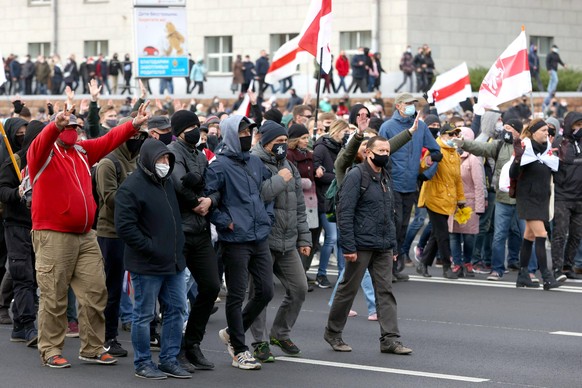 MINSK, BELARUS - NOVEMBER 1, 2020: People carry white-red-white flags as they take part in the Dziady opposition march in Independence Avenue. The annual march is held by the Belarusian opposition fro ...