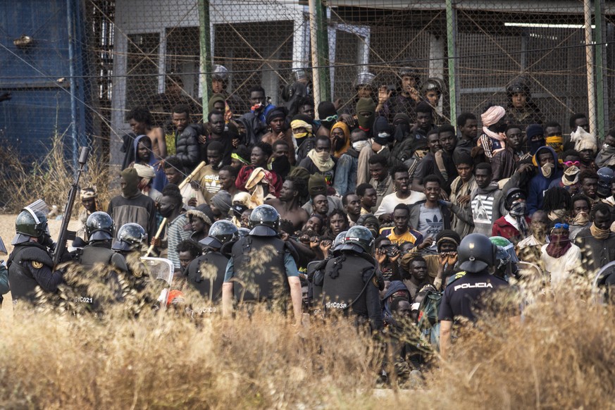 Beamte der Bereitschaftspolizei riegeln das Gebiet ab, nachdem Migranten in der spanischen Enklave Melilla in Marokko angekommen sind.