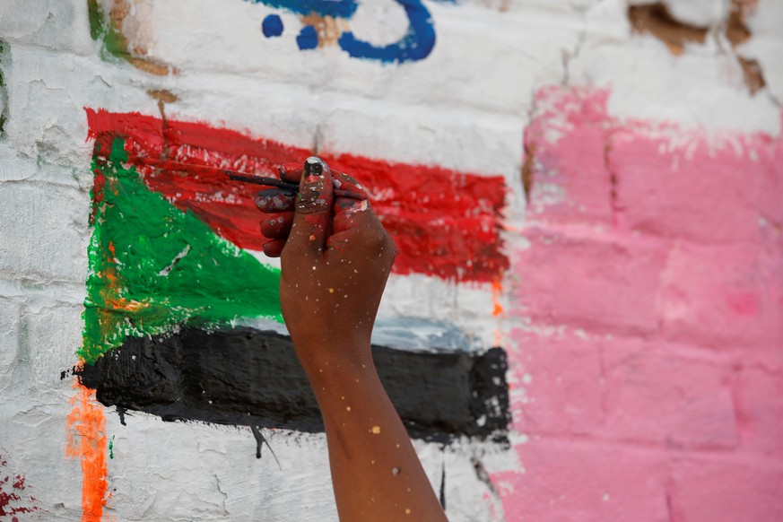 FILE PHOTO: Amna Almahi works on a mural near the defence ministry compound in Khartoum, Sudan, April 22, 2019. REUTERS/Umit Bektas/File Photo