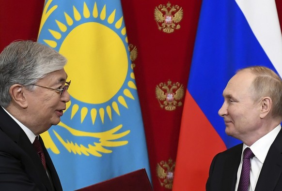 Russia's President Vladimir Putin, right, and Kazakhstan's President Kassym-Jomart Tokayev exchange documents after their talks at the Kremlin in Moscow, Russia, Monday, Nov. 28, 2022. Kazakhstan's le ...