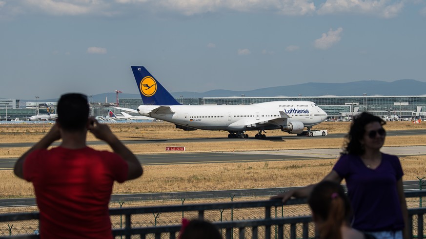 03.08.2018, Hessen, Frankfurt am Main: Ein Mann fotografiert am frankfurter Flughafen eine Boeing 747. Foto: Silas Stein/dpa +++ dpa-Bildfunk +++