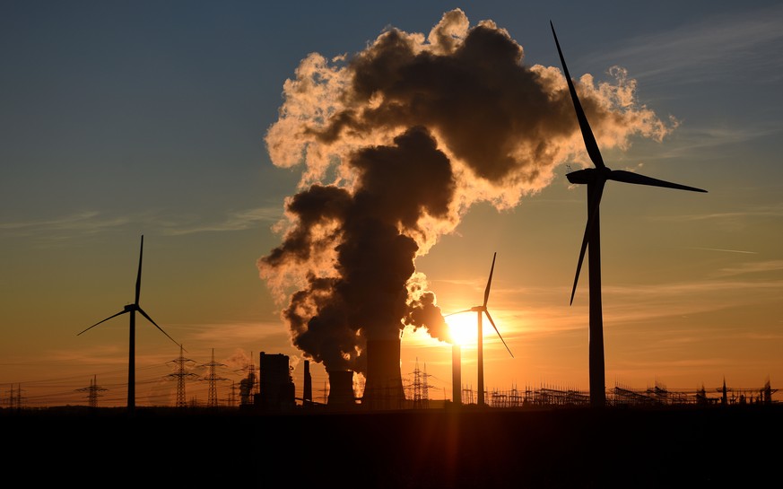 BERGHEIM, GERMANY - FEBRUARY 16: Electricity pylons and wind turbines stand beside the RWE Niederaussem coal-fired power plant while Steam rises from cooling towers on February 16, 2016 near Bergheim, ...