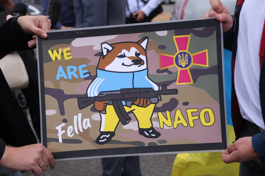 BERLIN, GERMANY - JULY 05: Activists hold up a small poster of the pro-Ukrainian NAFO Fellas meme movement at an event next to the Reichstag on July 05, 2023 in Berlin, Germany. The NAFO Fellas have p ...