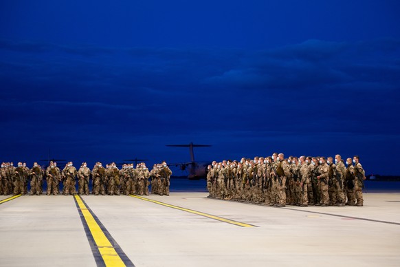 27.08.2021, Niedersachsen, Wunstorf: Soldaten stehen bei einem Appell in einem Hangar auf dem nieders�chsischen St�tzpunkt Wunstorf, im Hintergrund steht ein Transportflugzeug vom Typ A400M der Bundes ...