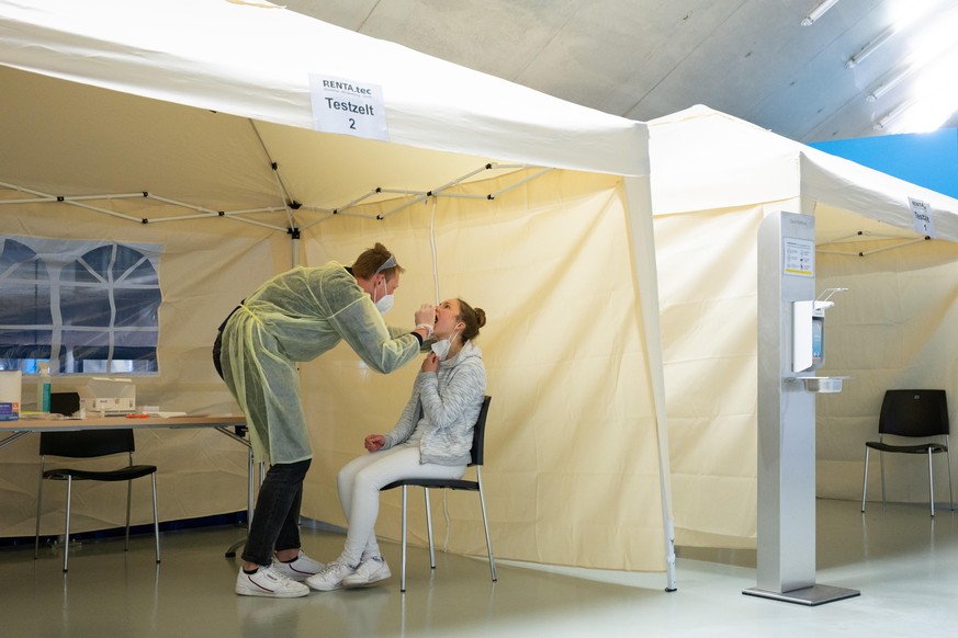 Anna Ritter sitzt im Corona-Testzentrum in der EnergieVerbund Arena vor Robert Lüderitz, Mitarbeiter im Testzentrum. Das Testzentrum in der Eissporthalle bietet kostenlose Bürgertests und auch kostenp ...