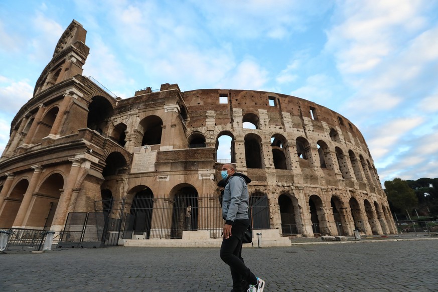 04.11.2020, Italien, Rom: Ein Passant geht vorbei am Kolosseum. Italiens Premierminister Conte hat die Ma