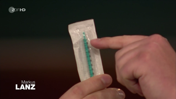 Der Arzt zeigt die Spritze, mit der auch sieben Impfdosen aus einer Ladung herausgezogen werden können.